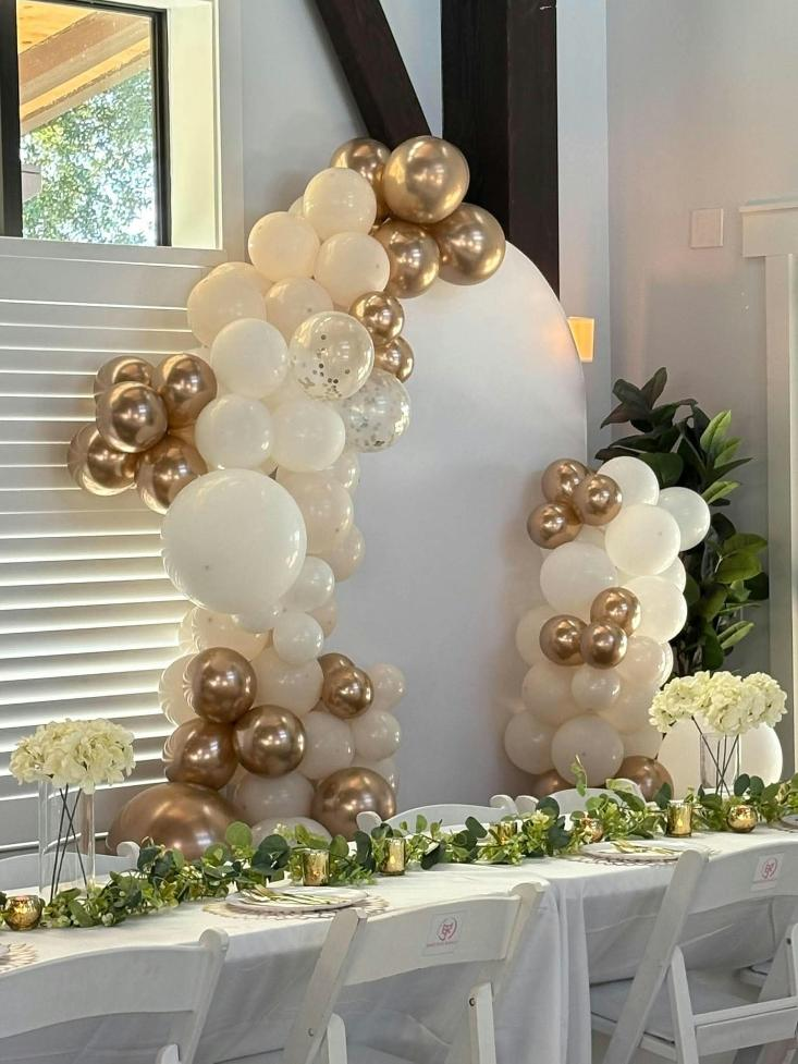 White and gold balloon arch at indoor birthday event in Sarasota Flroida