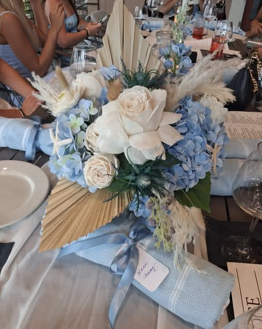 Beautifully styled event table with blue and white floral arrangements and coordinated place settings.