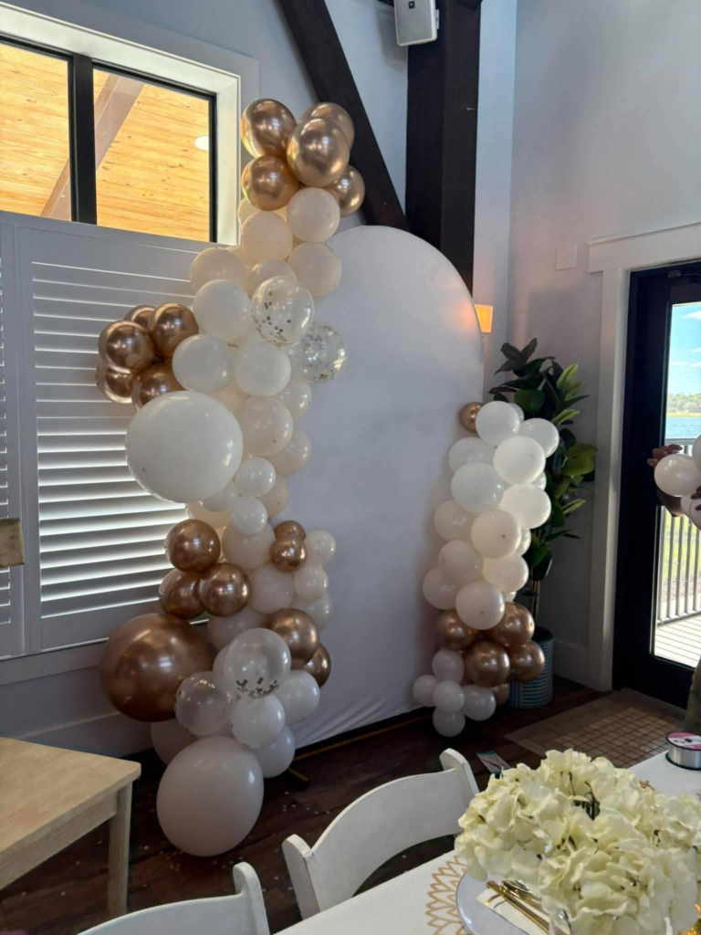 Neutral balloon installation arranged as a decorative backdrop for a birthday party or social celebration.
