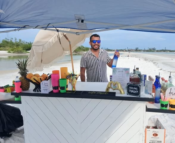 Mobile bartender serving drinks from a beachside bar at an outdoor celebration on Florida's Gulf Coast