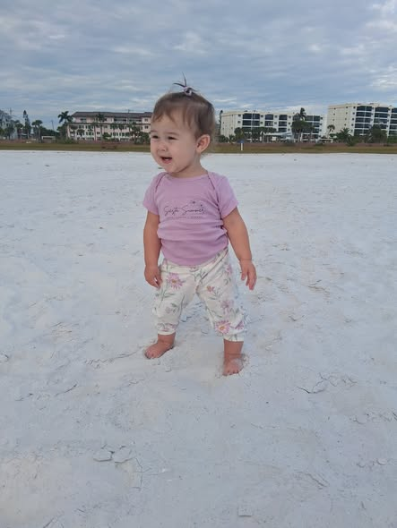 Mirand's young daughter playing in the whute sand on the sunny Sarasota-area beach